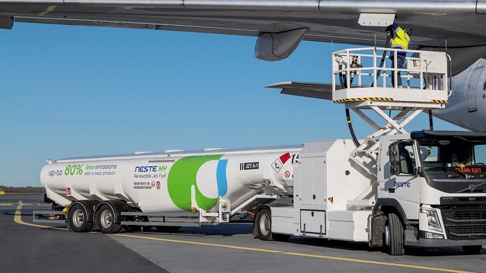 Neste fuel vehicle next to airplane 