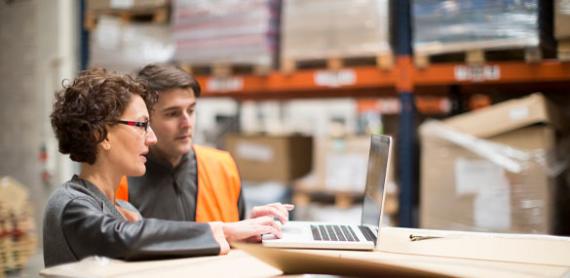 Employees working with IT-equipment in distribution center