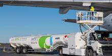 A fuel vehicle of Neste next to airplane